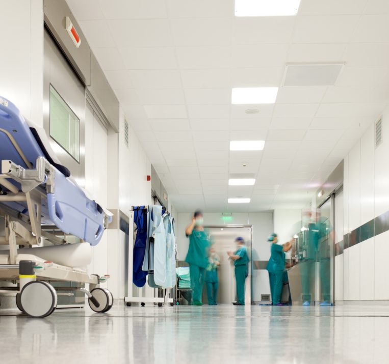 Blurred figures of people with medical uniforms in hospital corridor